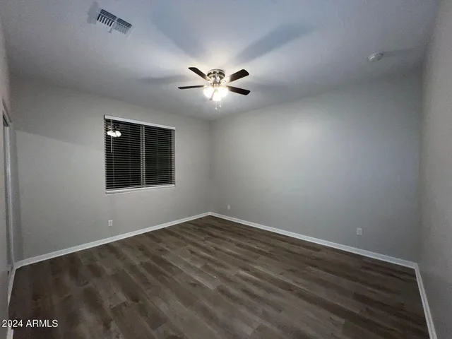 a view of an empty room with a ceiling fan and a window