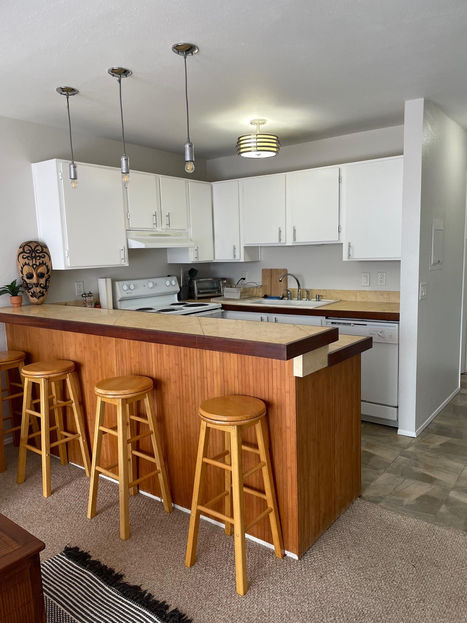 3740 Lower Honoapiilani Road, Unit G205 Lahaina, HI 96761 - Photo 2 of 8 a kitchen with kitchen island granite countertop a sink a counter top space and cabinets