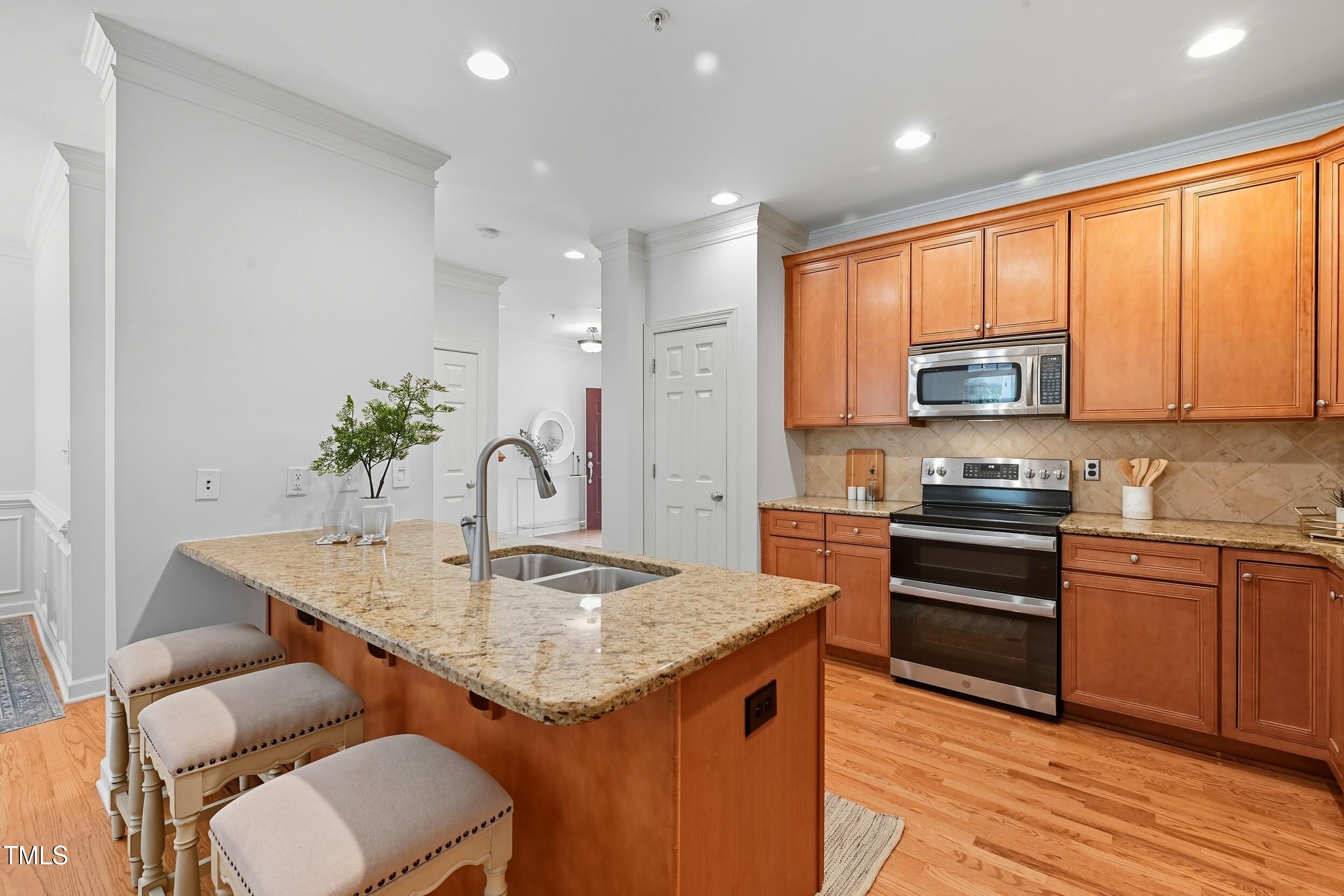 222 Towne Ridge Lane Chapel Hill, NC 27516 - Photo 11 of 39 a kitchen with stainless steel appliances granite countertop a kitchen island hardwood floor sink stove and granite counter top