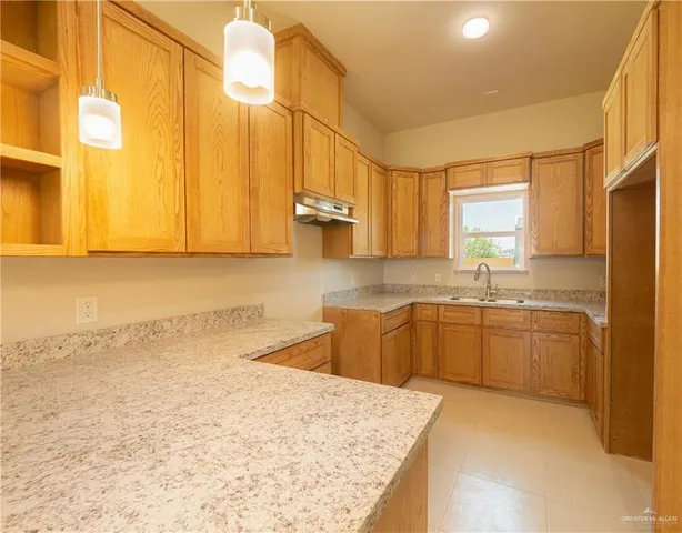 a kitchen with stainless steel appliances granite countertop a sink refrigerator and cabinets