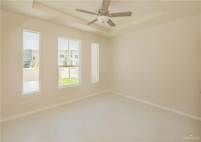 an empty room with windows and fan