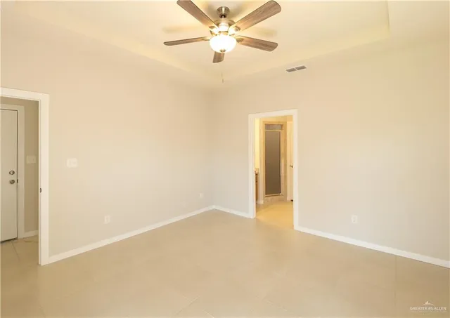 an empty room with closet and a ceiling fan