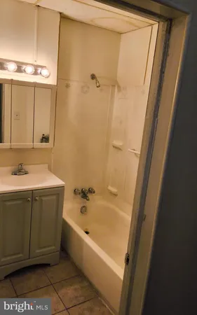 a bathroom with a tub sink and mirror