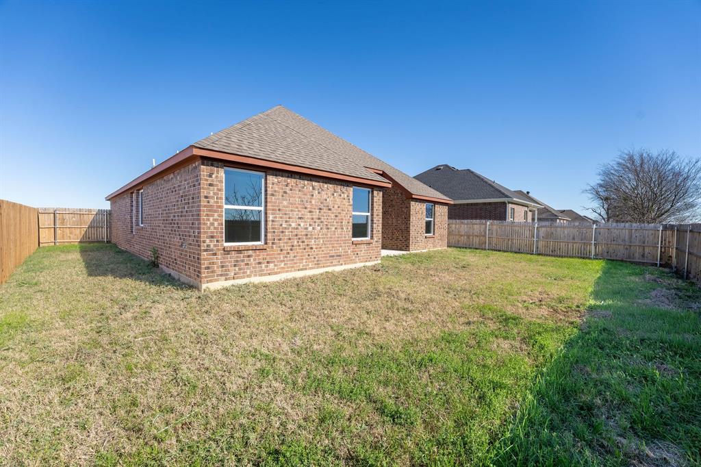 1020 Springview Lane Mabank, TX 75147 - Photo 15 of 15 Back of property featuring a fenced backyard, roof with shingles, and brick siding