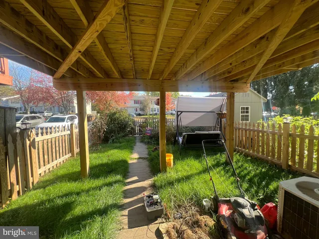 a view of a patio with table and chairs potted plants and floor to ceiling window