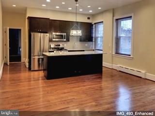 a kitchen with stainless steel appliances granite countertop a refrigerator a sink a stove and oven