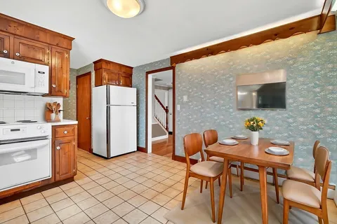 a dining room with furniture a rug and a refrigerator
