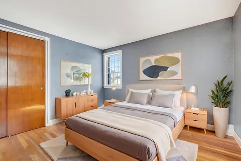 a bedroom with a bed and painting on the wall