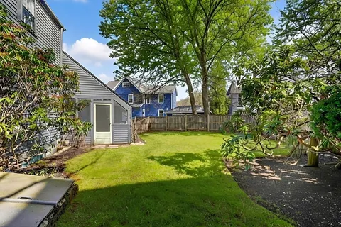 a view of a house with backyard and sitting area