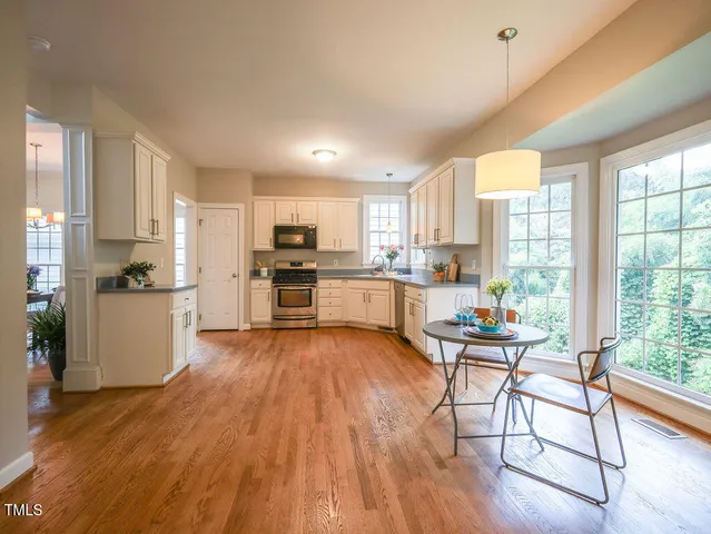 a kitchen with stainless steel appliances wooden floors and wooden cabinets