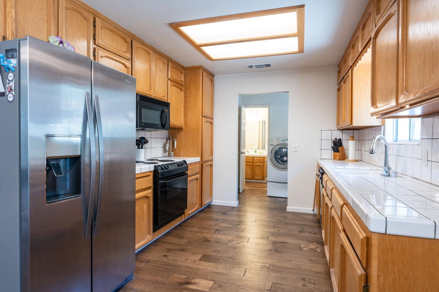 43142 Ellen Mine Road Coarsegold, CA 93614 - Photo 14 of 29 a kitchen with stainless steel appliances granite countertop a refrigerator a stove and a sink