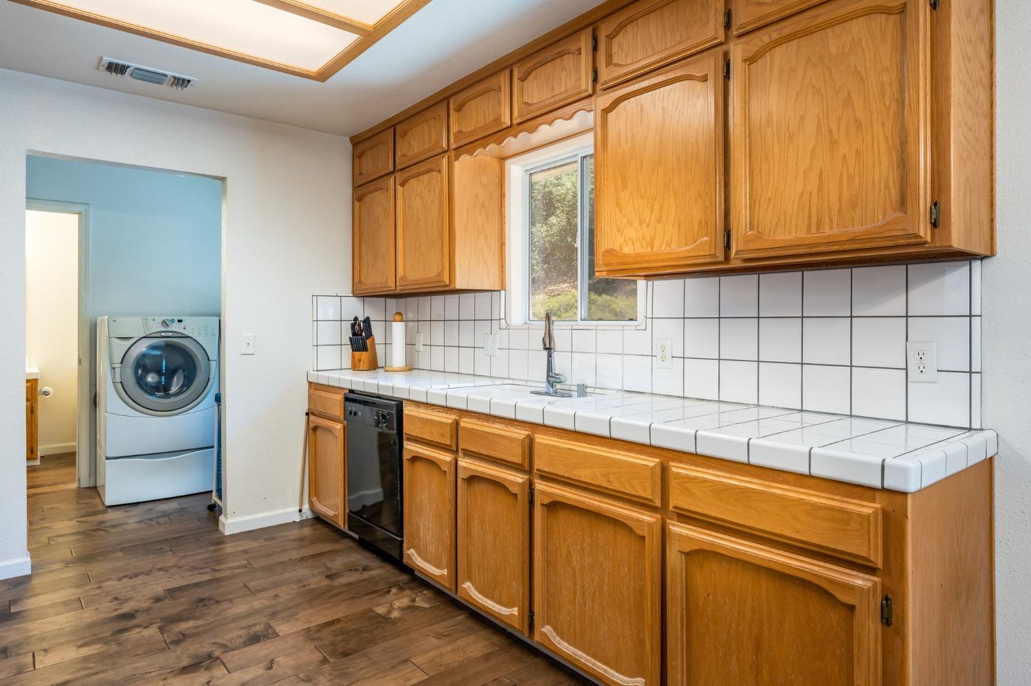 43142 Ellen Mine Road Coarsegold, CA 93614 - Photo 15 of 29 a kitchen with stainless steel appliances granite countertop a sink and cabinets with wooden floor