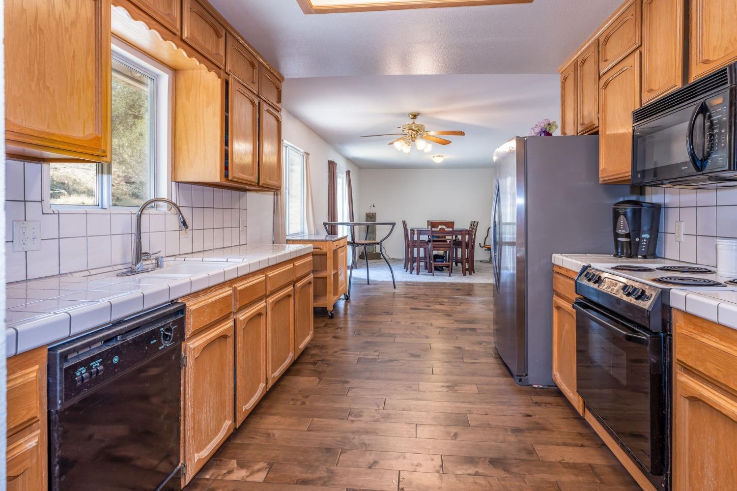 43142 Ellen Mine Road Coarsegold, CA 93614 - Photo 16 of 29 a large kitchen with stainless steel appliances granite countertop a stove and a sink