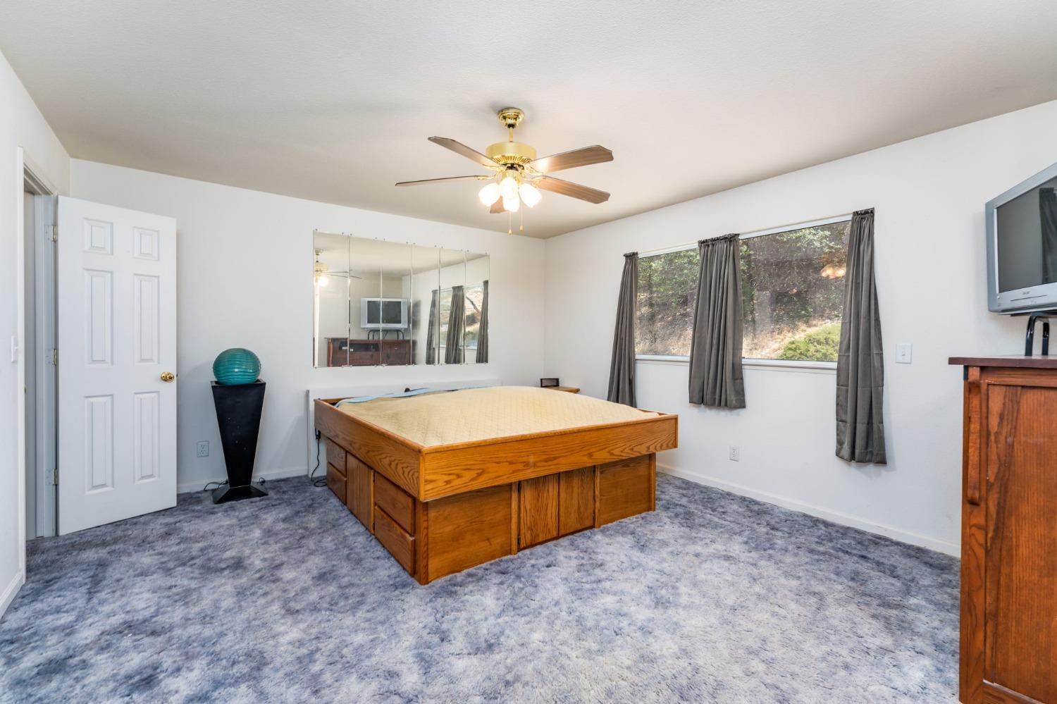43142 Ellen Mine Road Coarsegold, CA 93614 - Photo 21 of 29 a spacious bedroom with a bed closet and a window