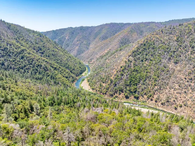 a view of a dry yard with mountains in the background