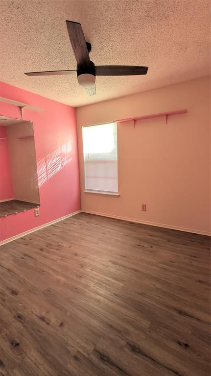 2204 Crestmeadow Street Denton, TX 76207 - Photo 20 of 21 an empty room with wooden floor and windows