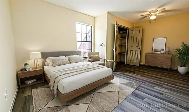 a bedroom with a bed wooden floor and window