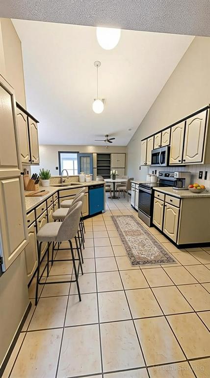 2204 Crestmeadow Street Denton, TX 76207 - Photo 9 of 21 a open kitchen with stainless steel appliances kitchen island granite countertop a sink and cabinets