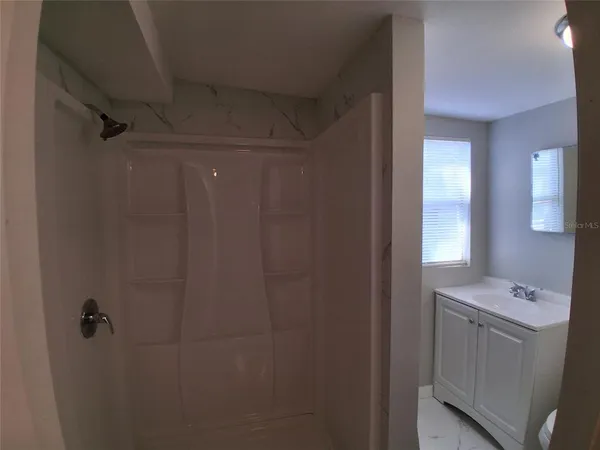 a bathroom with a shower a sink and a mirror