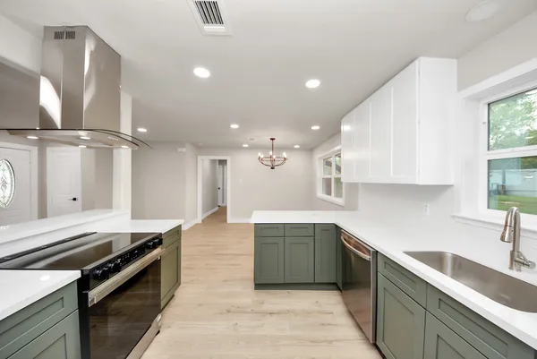 a kitchen with stainless steel appliances granite countertop a sink a stove and a refrigerator