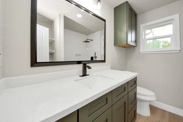 a bathroom with a sink a toilet and mirror