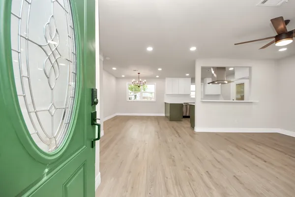 an entryway with wooden floor and windows