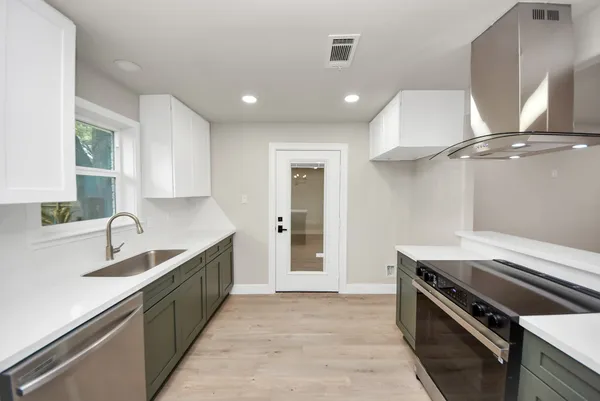 a kitchen with a sink and a stove top oven