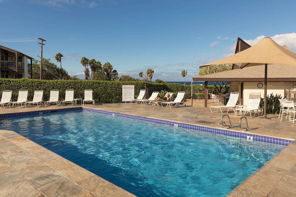 2737 South Kihei Road, Unit 126 Kihei, HI 96753 - Photo 23 of 25 a view of a swimming pool with a lawn chairs under an umbrella