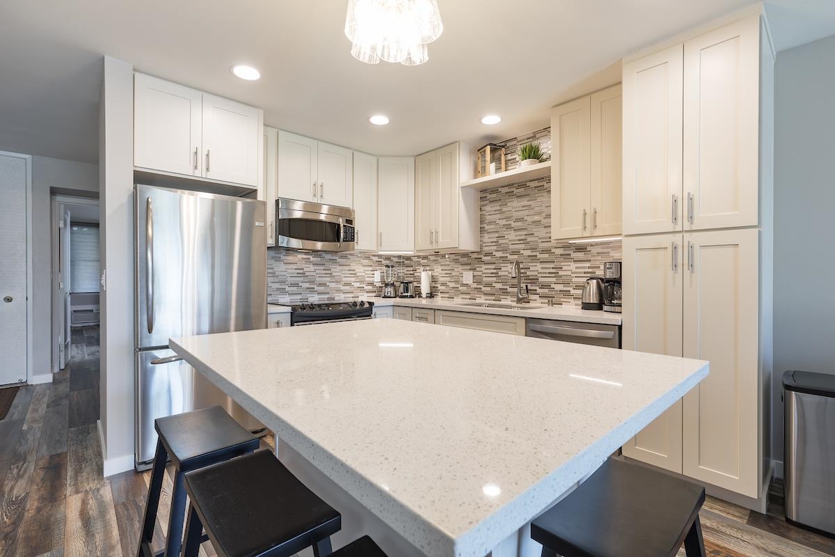2737 South Kihei Road, Unit 126 Kihei, HI 96753 - Photo 3 of 25 a large kitchen with kitchen island white cabinets and stainless steel appliances