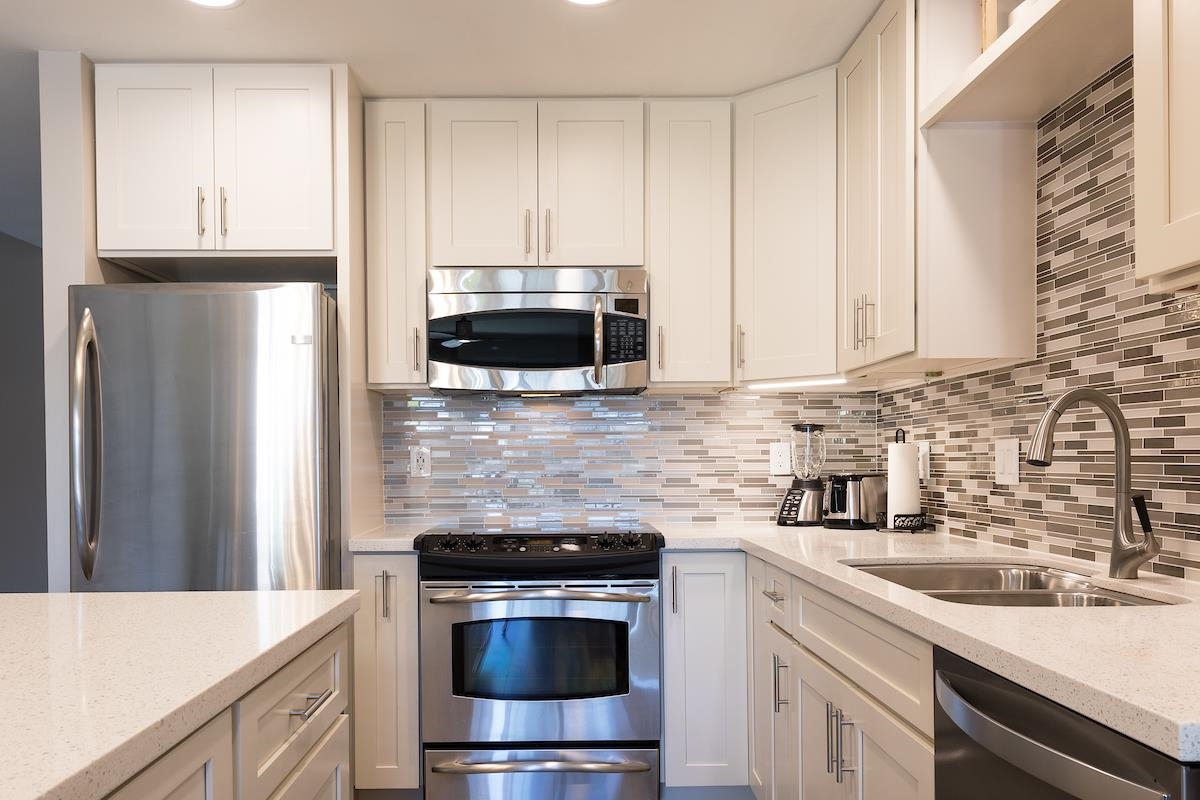 2737 South Kihei Road, Unit 126 Kihei, HI 96753 - Photo 6 of 25 a kitchen with stainless steel appliances a stove a sink and a microwave