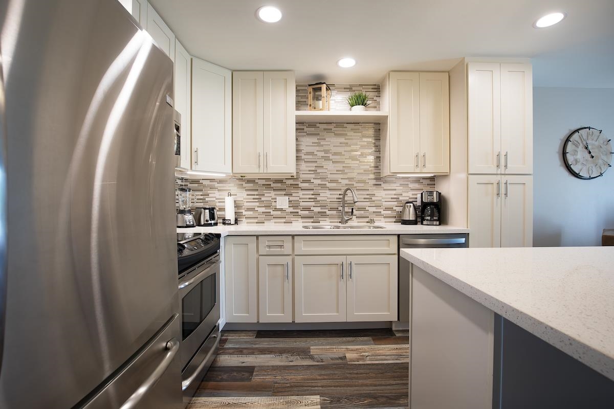 2737 South Kihei Road, Unit 126 Kihei, HI 96753 - Photo 7 of 25 a kitchen with white cabinets and white appliances