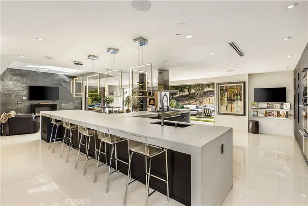 a large white kitchen with a large window and stainless steel appliances