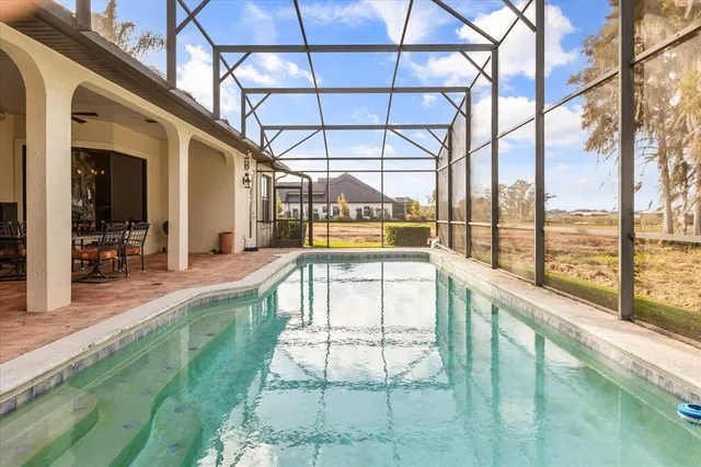 a spacious bedroom with a bed painting on wall and a large window
