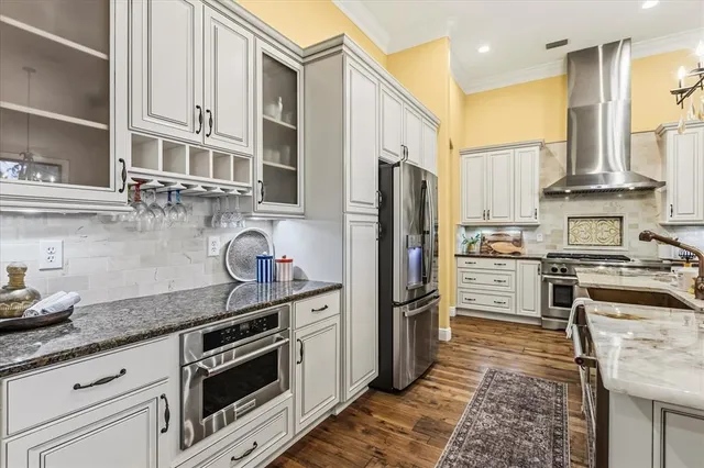 a kitchen with stainless steel appliances granite countertop a refrigerator stove and sink