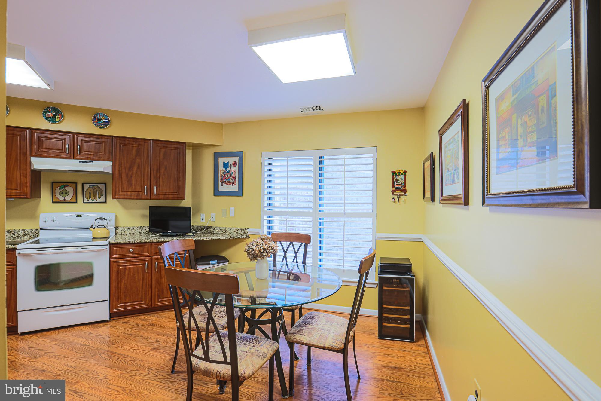 3041 Fallstaff Road, Unit 304D Baltimore, MD 21209 - Photo 24 of 39 a view of a dining room with furniture a chandelier and wooden floor