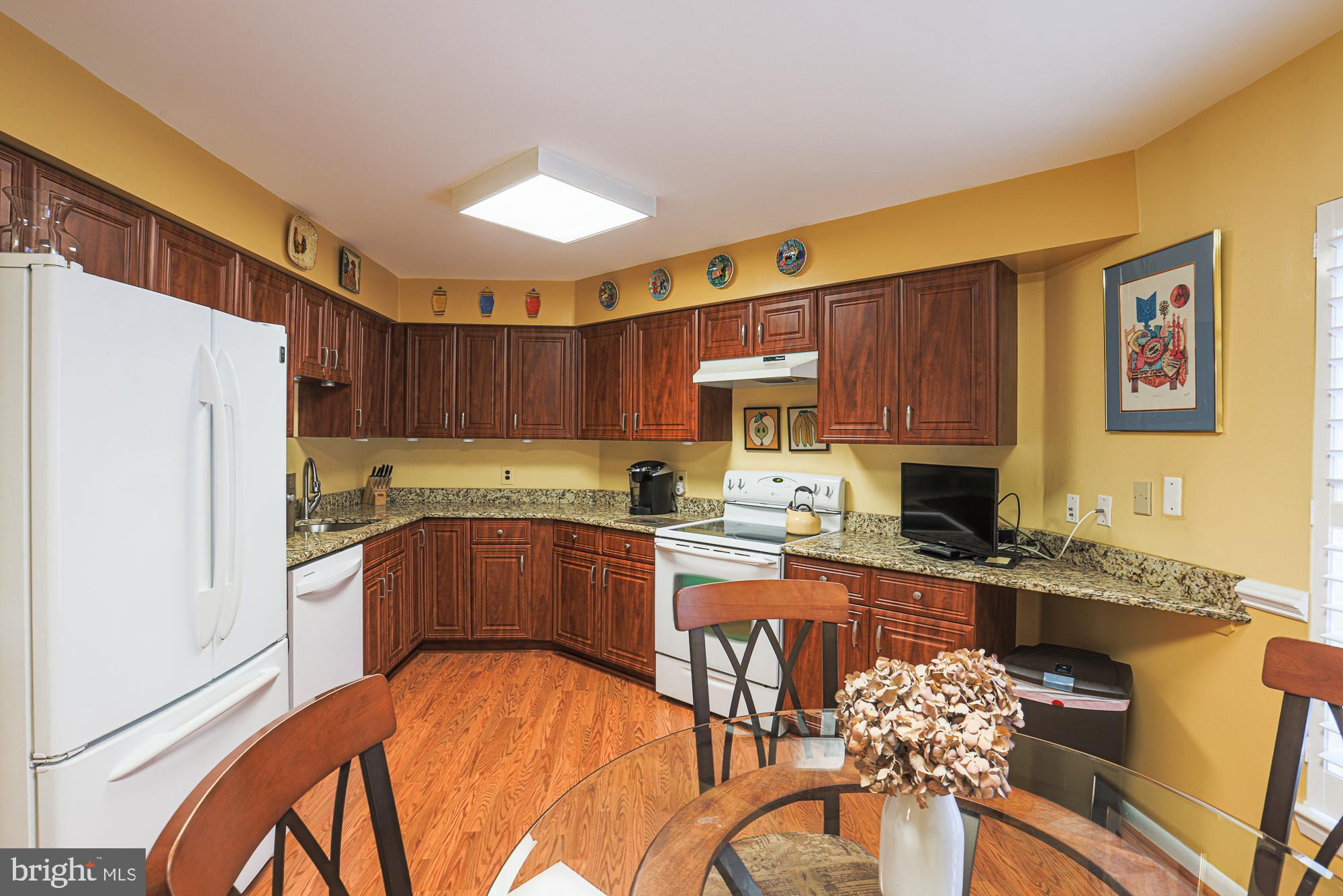 3041 Fallstaff Road, Unit 304D Baltimore, MD 21209 - Photo 25 of 39 a kitchen with stainless steel appliances granite countertop a refrigerator a sink dishwasher a stove with wooden cabinets and floor