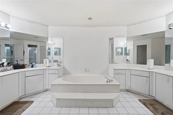 a bathroom with a tub sink and mirror