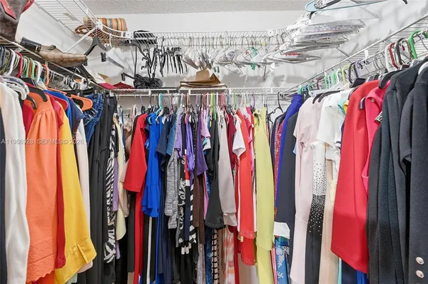 a view of walk in closet with clothes and shoes