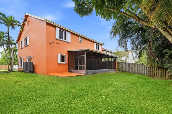 a view of a house with a yard and a tree