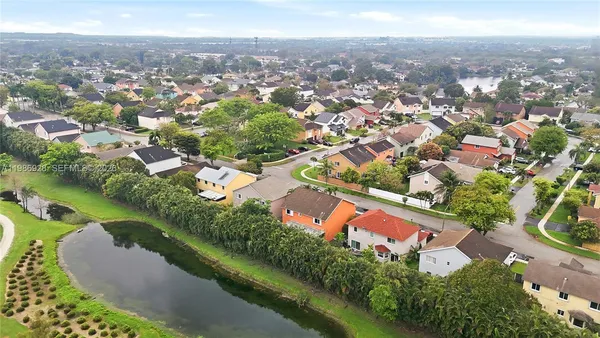 an aerial view of residential houses with outdoor space and trees