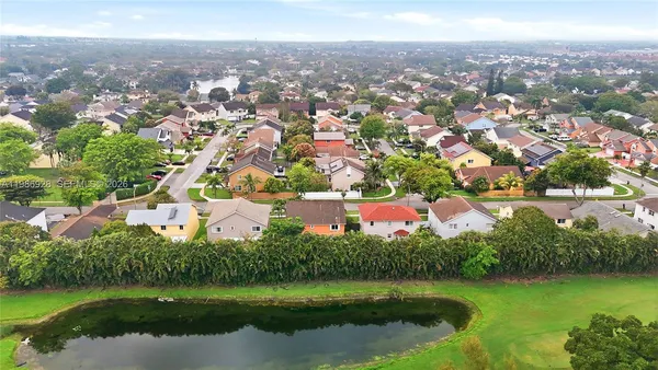 an aerial view of residential houses with outdoor space and lake view