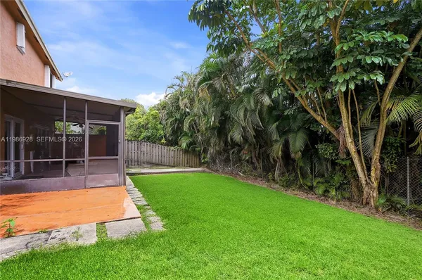 a view of a backyard with table and chairs and potted plants with wooden fence