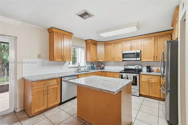 a kitchen with stainless steel appliances granite countertop a sink counter space cabinets and a window