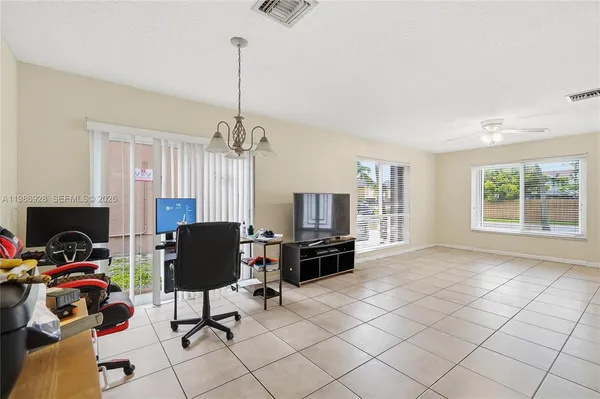 a view of a workspace with furniture and a window