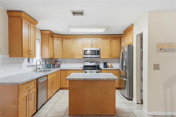 a kitchen with stainless steel appliances granite countertop a refrigerator stove microwave and sink