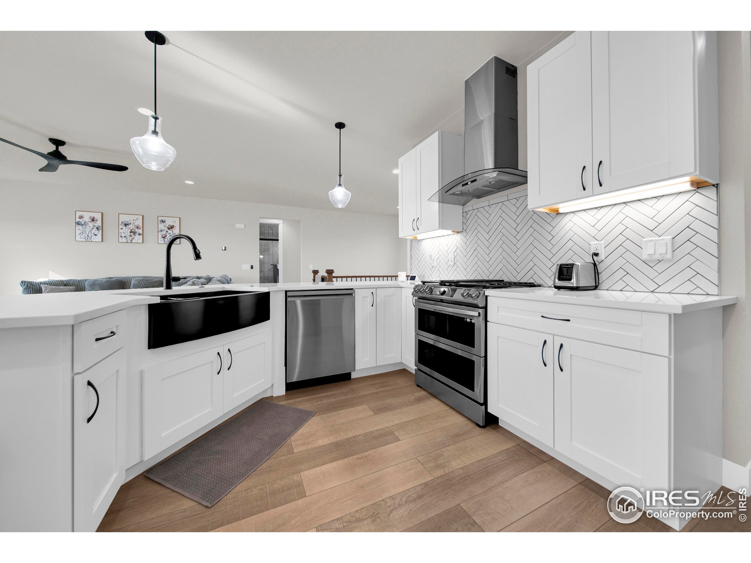 116 7th Avenue Wiggins, CO 80654 - Photo 13 of 42 a kitchen with white cabinets stainless steel appliances and sink
