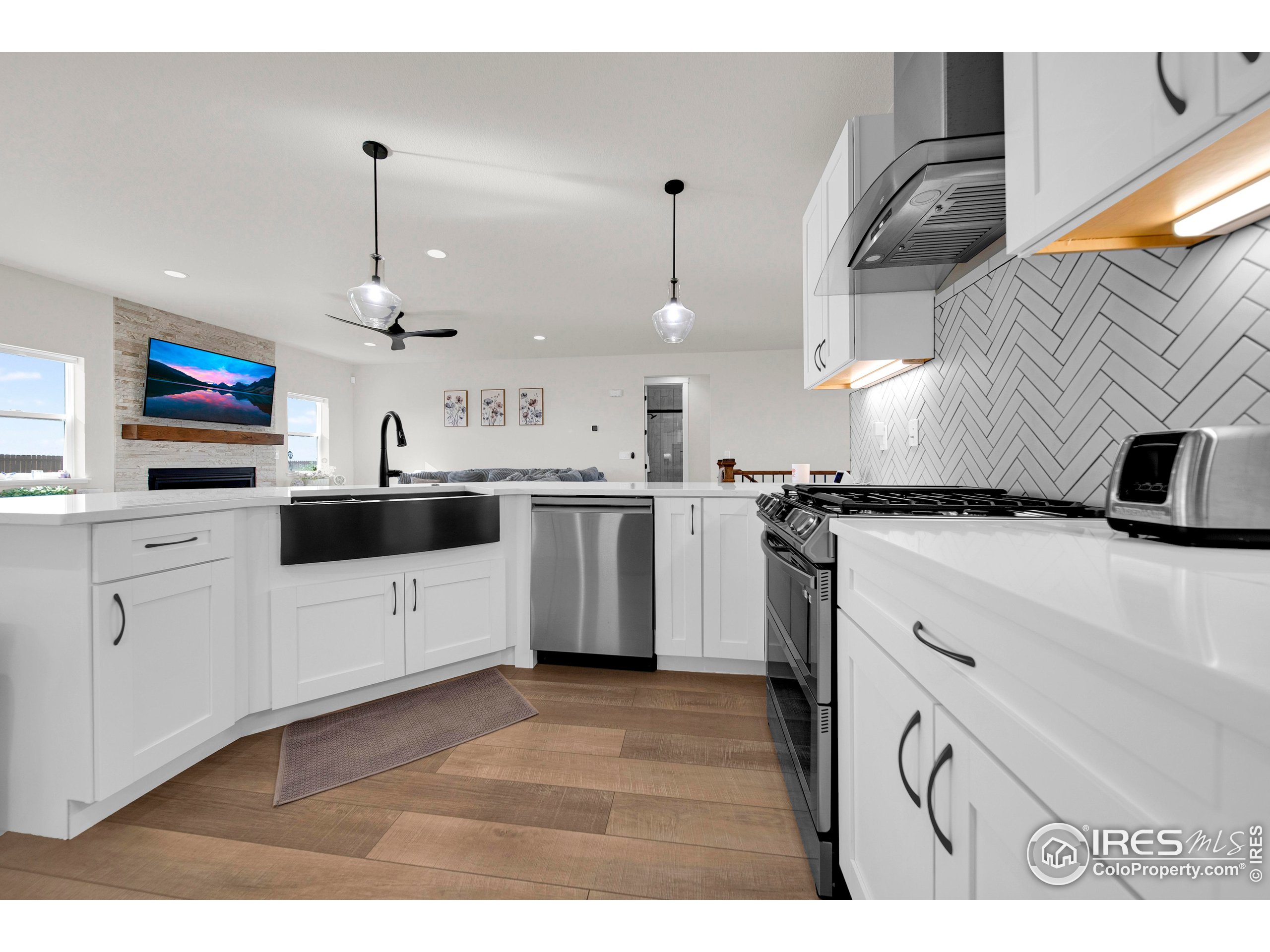 116 7th Avenue Wiggins, CO 80654 - Photo 14 of 42 a kitchen with stainless steel appliances kitchen island granite countertop a sink a stove and cabinets