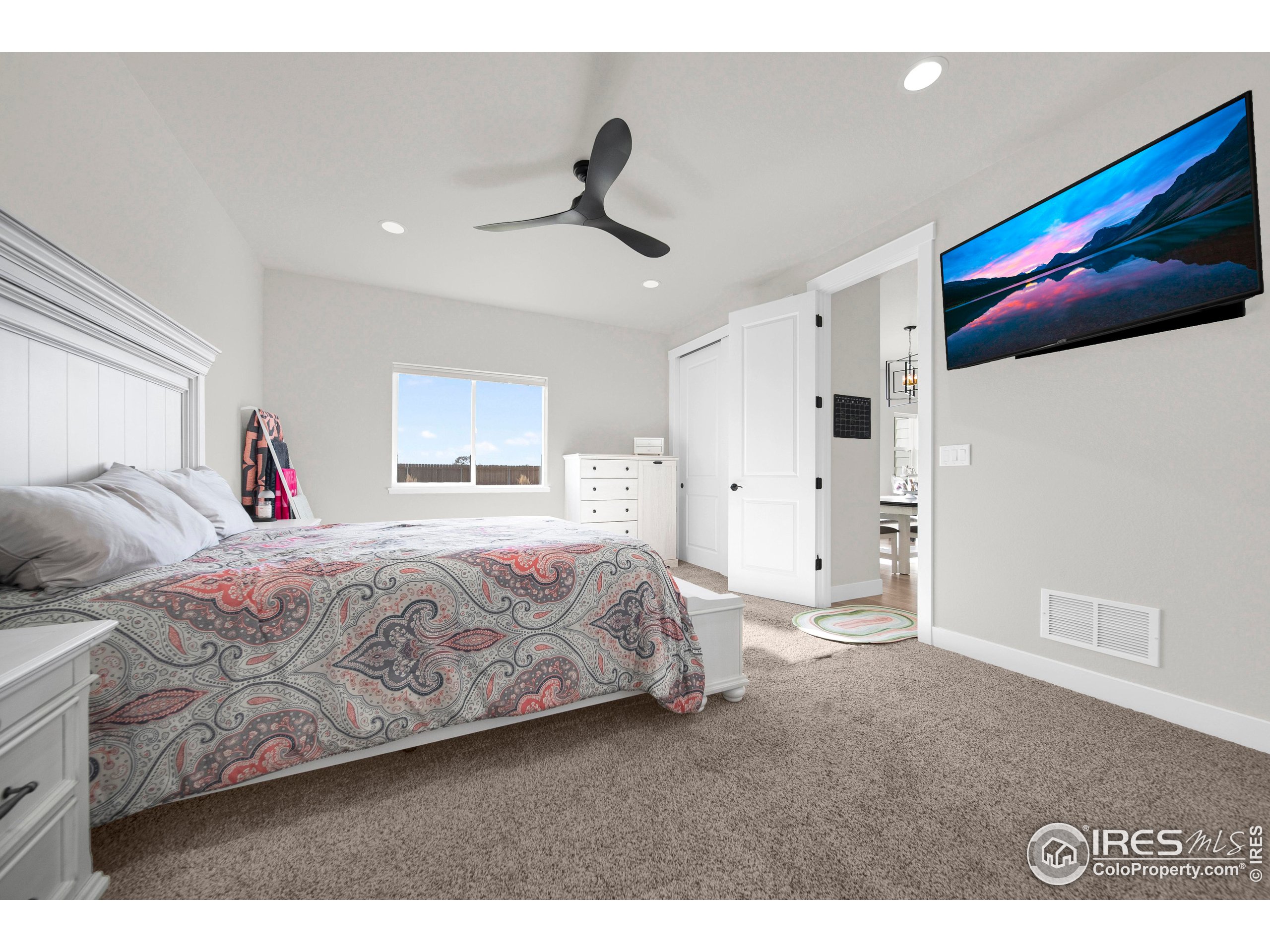 116 7th Avenue Wiggins, CO 80654 - Photo 20 of 42 a spacious bedroom with a bed and a flat screen tv