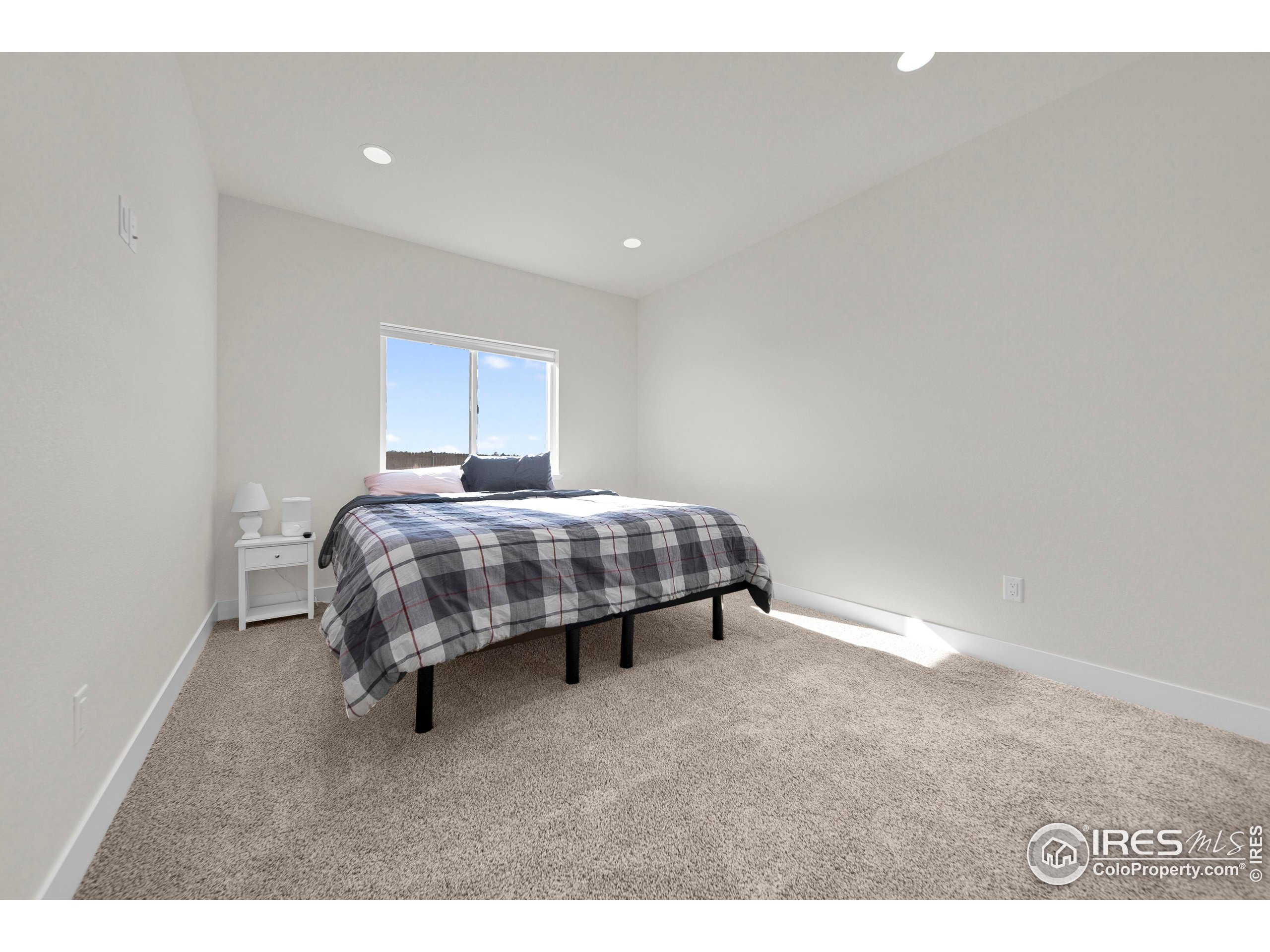 116 7th Avenue Wiggins, CO 80654 - Photo 27 of 42 a bedroom with a bed and a night stand