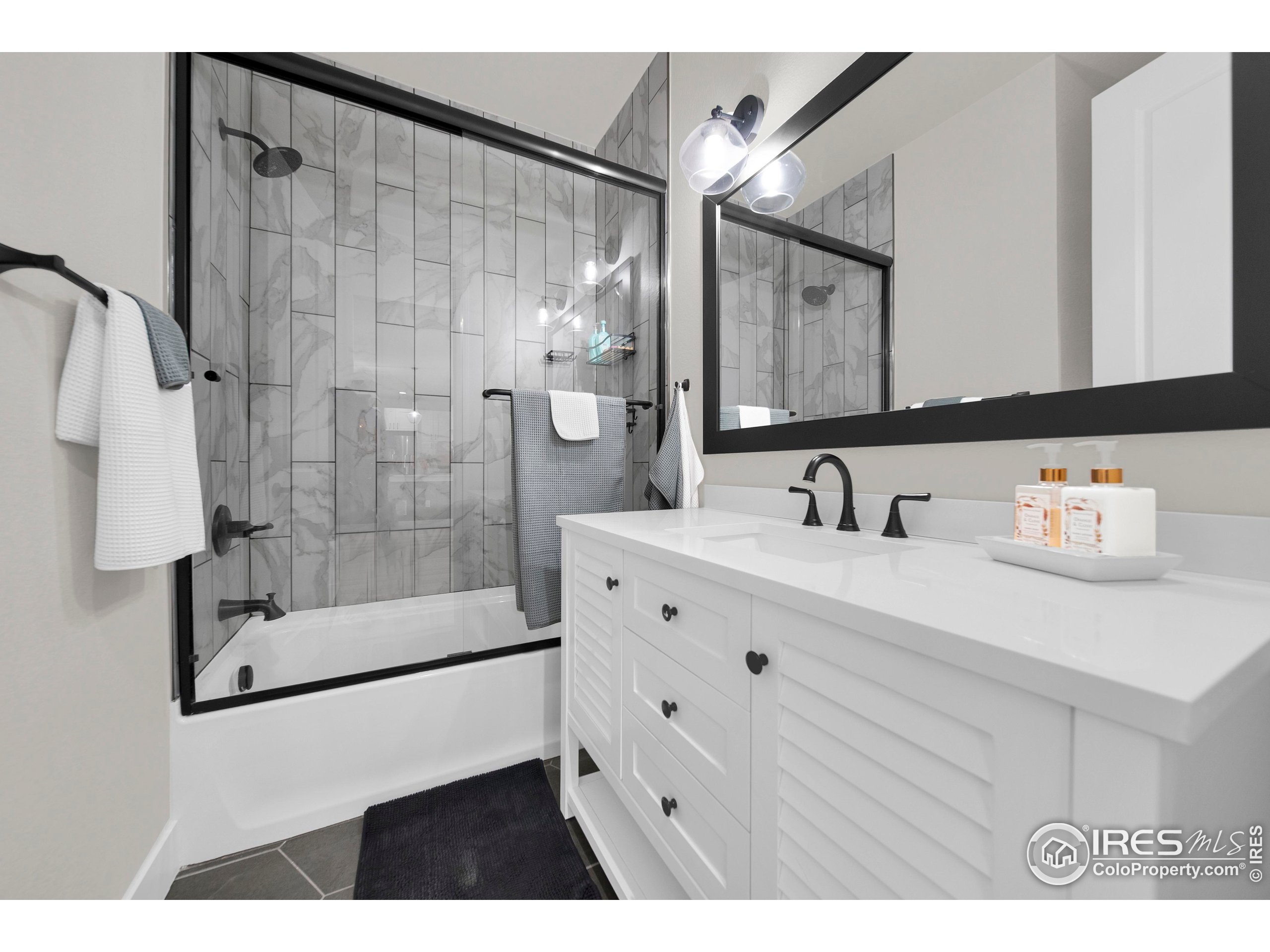 116 7th Avenue Wiggins, CO 80654 - Photo 28 of 42 a bathroom with a sink a shower a mirror and a bathtub